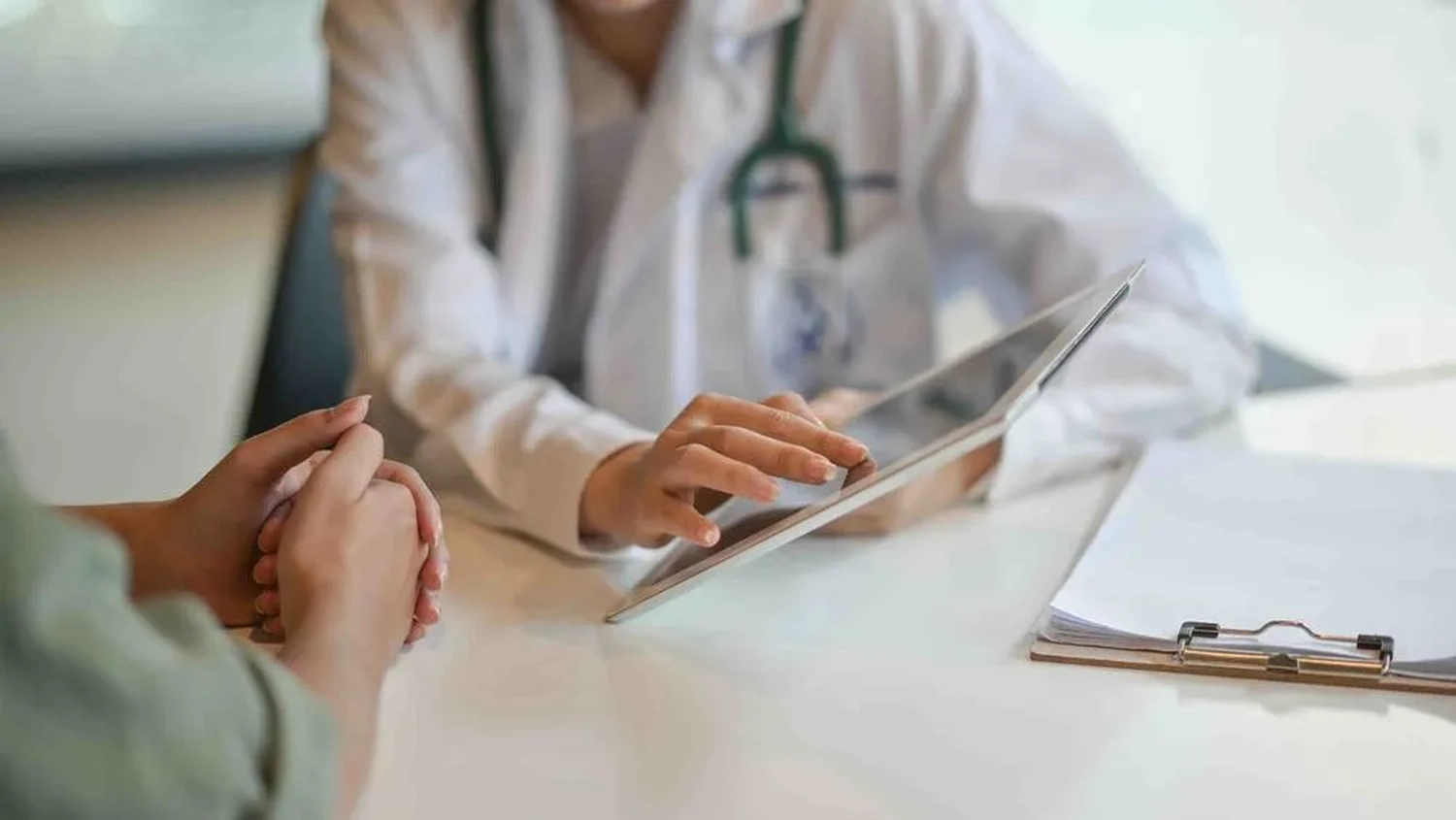 Aufnahme eines Arztes, der einer Patientin Informationen auf einem Tablet zeigt